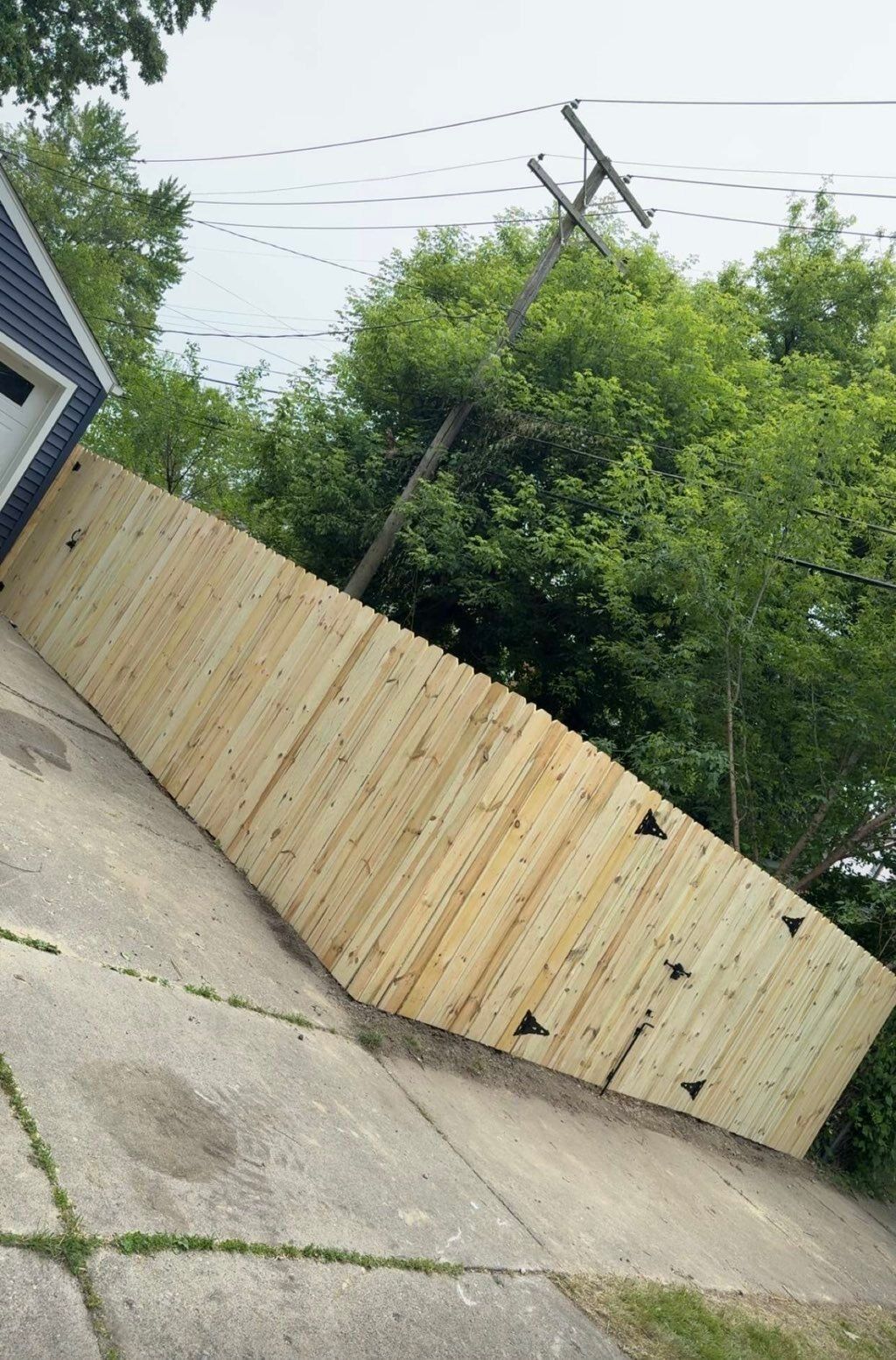 Wood privacy fence stepping down a sloped sidewalk